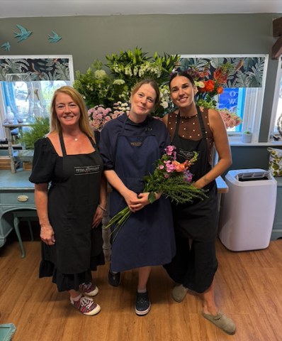 Helen, Astrid and Gemma, the florists at The Petal Boutique in Weyhill, together in the shop with a hand-tied bouquet